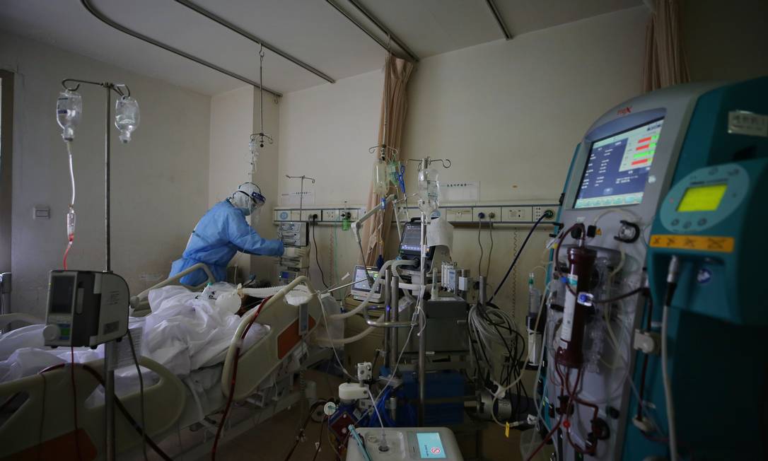 Médico usa proteção para atender paciente com Covid-19 em hospital na China Foto: STR / AFP