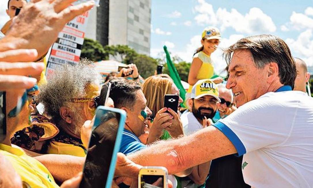 Bolsonaro cumprimenta apoiadores em manifestação, domingo: presidente quebrou protocolos da OMS e se expôs ao contágio por coronavírus Foto: SERGIO LIMA/AFP/15-3-2019