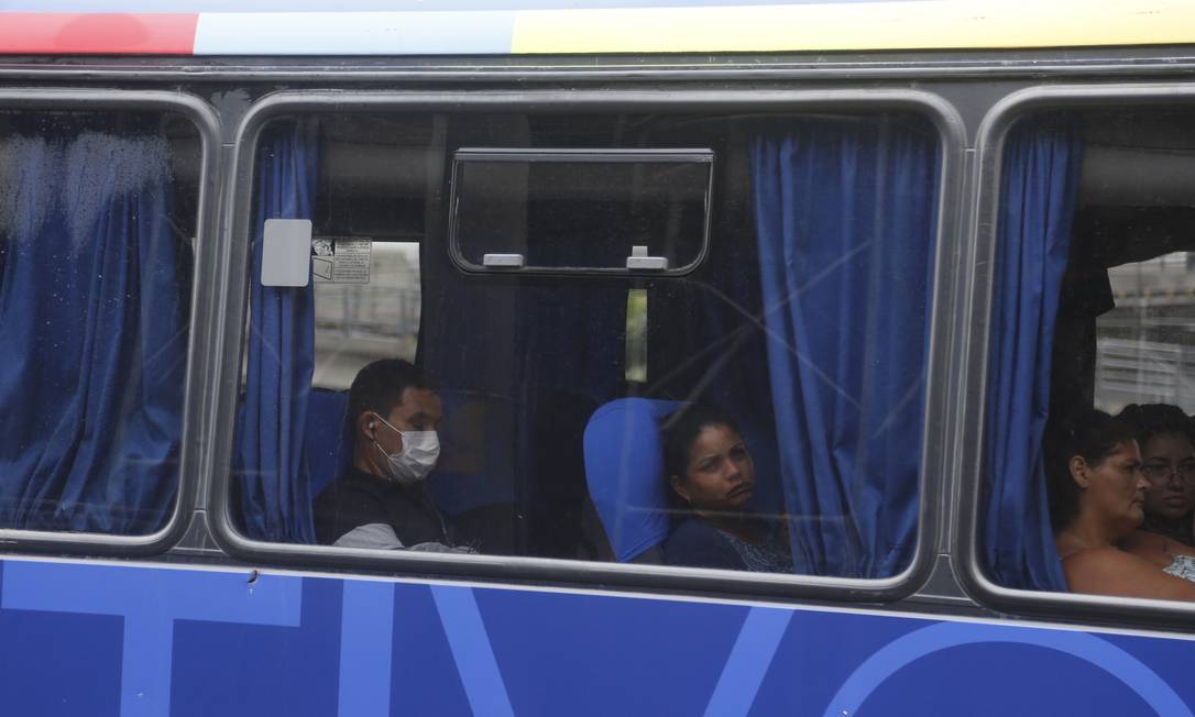 Rapaz usa máscara dentro de um ônibus no Rio Foto: Fabiano Rocha / O Globo