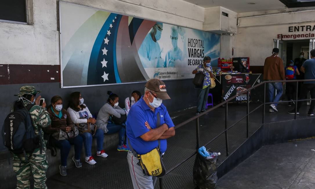 Pacientes com máscara esperam do lado de fora do Hospital Vargas, em Caracas Foto: CRISTIAN HERNANDEZ / AFP