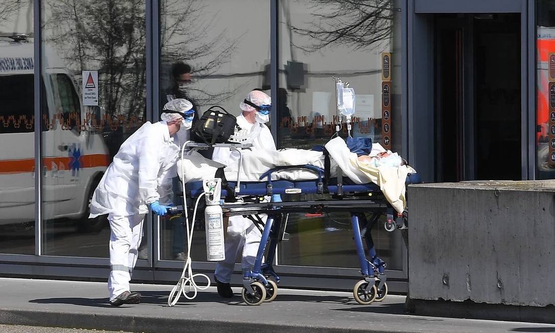 Paciente com respirador é transferido por equipe médica em hospital, em Strasbourg Foto: PATRICK HERTZOG / AFP