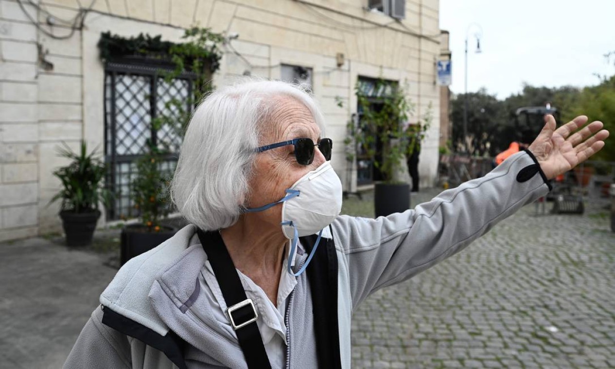 Idosa de 83 anos usa máscara facial quando sai para fazer compras no centro de Roma. Mais vulneráveis, idosos são o alvo favorito do coronavírus: falecidos na Itália têm idade média de 80 anos Foto: VINCENZO PINTO / AFP