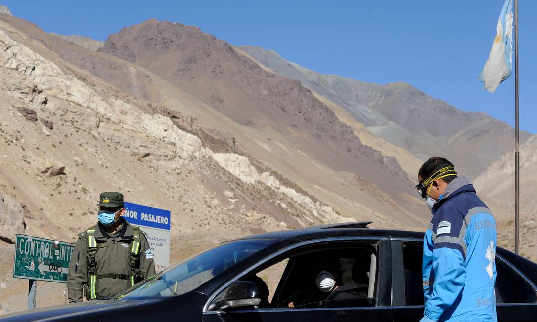 Agentes e motorista usam máscara na fronteira da Argentina com o Chile Foto: ANDRES LARROVERE/AFP / AFP