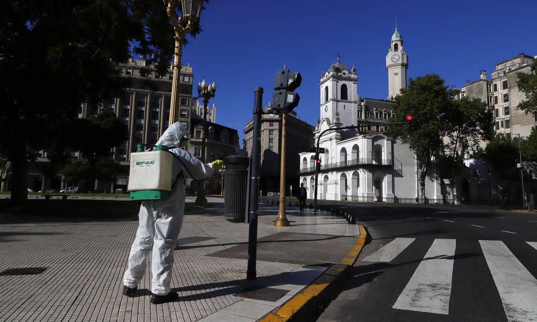 Homem desinfeta a Praça de Maio: argentinos estão em casa Foto: MATIAS BAGLIETTO / REUTERS