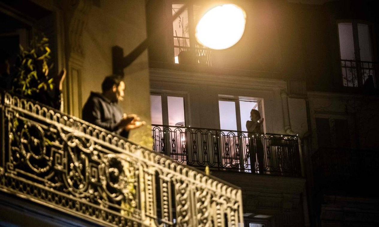 Às 20h da noite da última sexta-feira, parisienses aplaudiram profissionais da saúde que atuam na linha de frente contra a Covid-19 Foto: MARTIN BUREAU / AFP