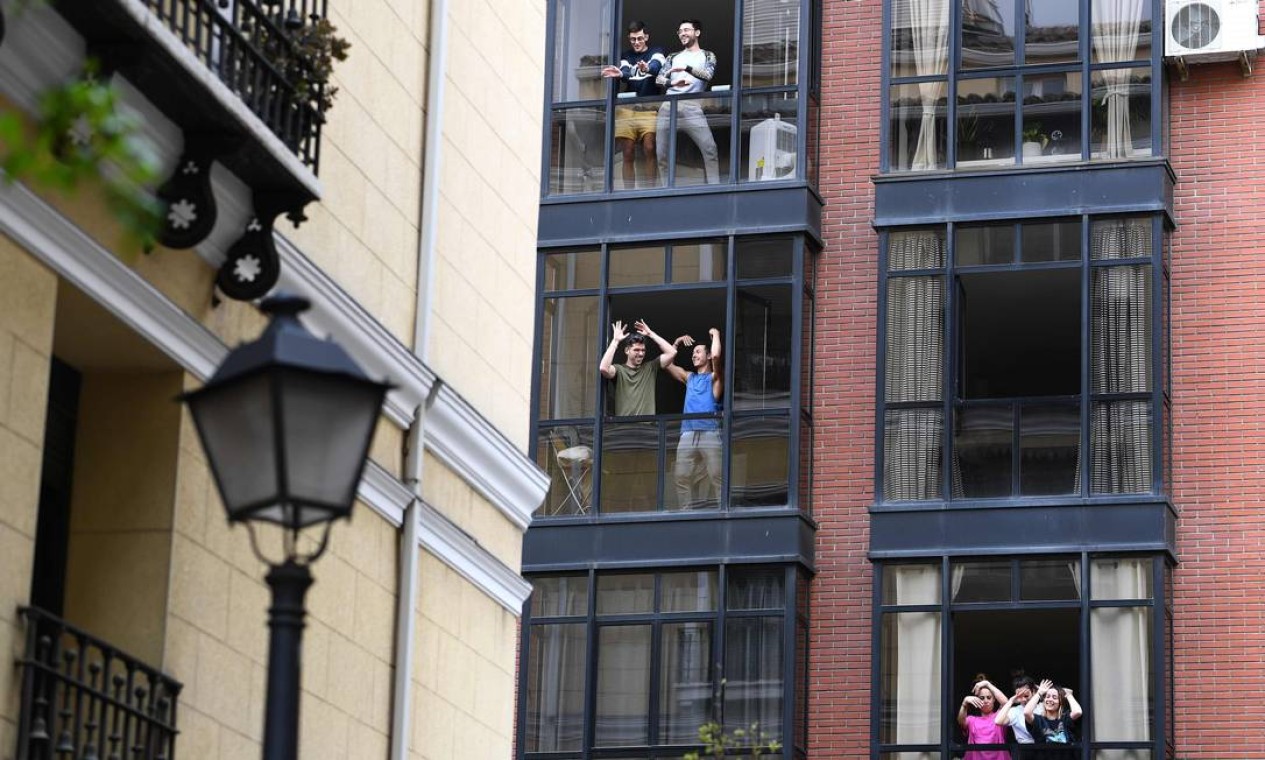 Espanhóis dançam da janela de casa em Madri, na última terça-feira Foto: GABRIEL BOUYS / AFP