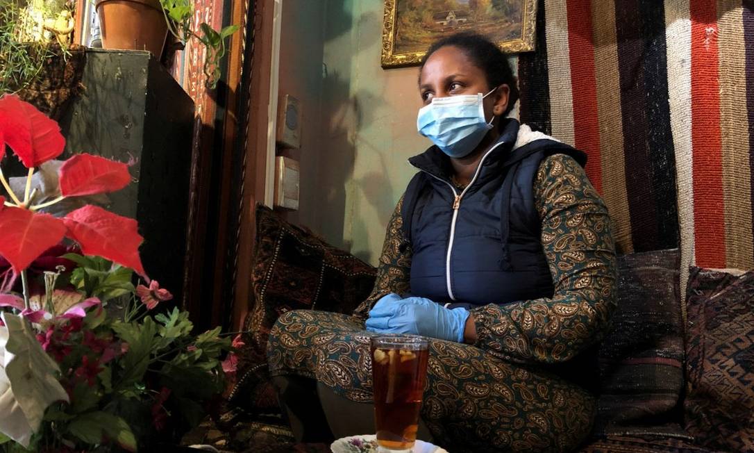 Mulher usa máscara e luva em restaurante da Cidade do Cabo Foto: Sumaya Hisham / REUTERS