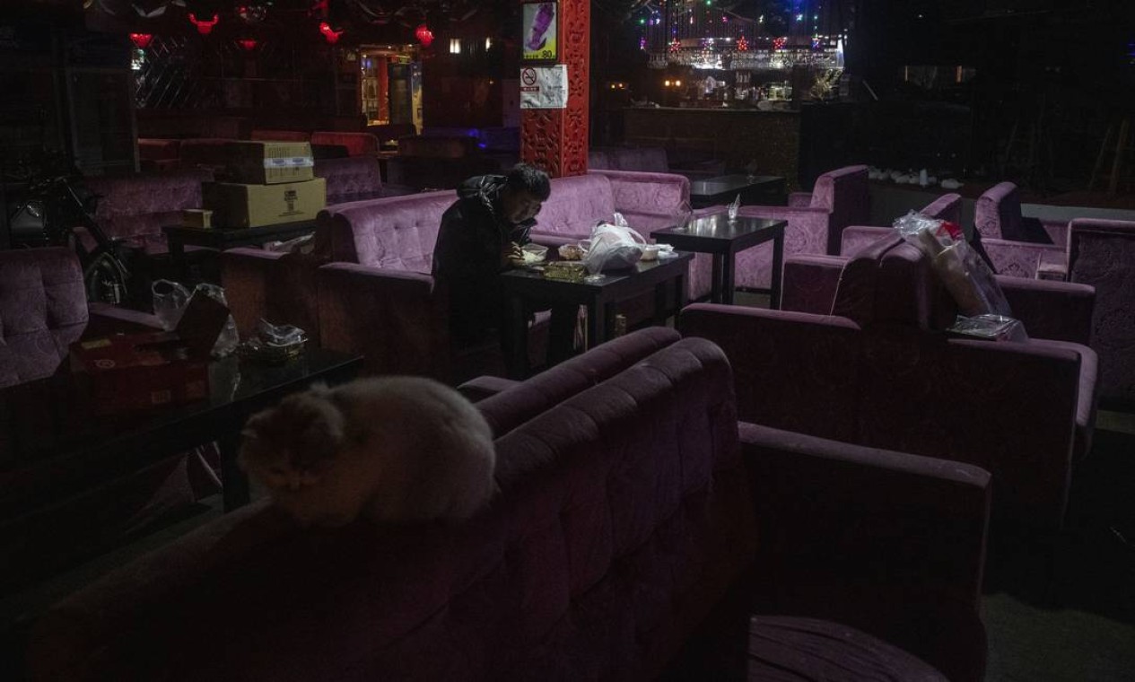 Um homem solitário janta em um bar fechado em um bairro de Pequim, na China, conhecido por sua animada vida noturna Foto: Gilles Sabrie / NYT
