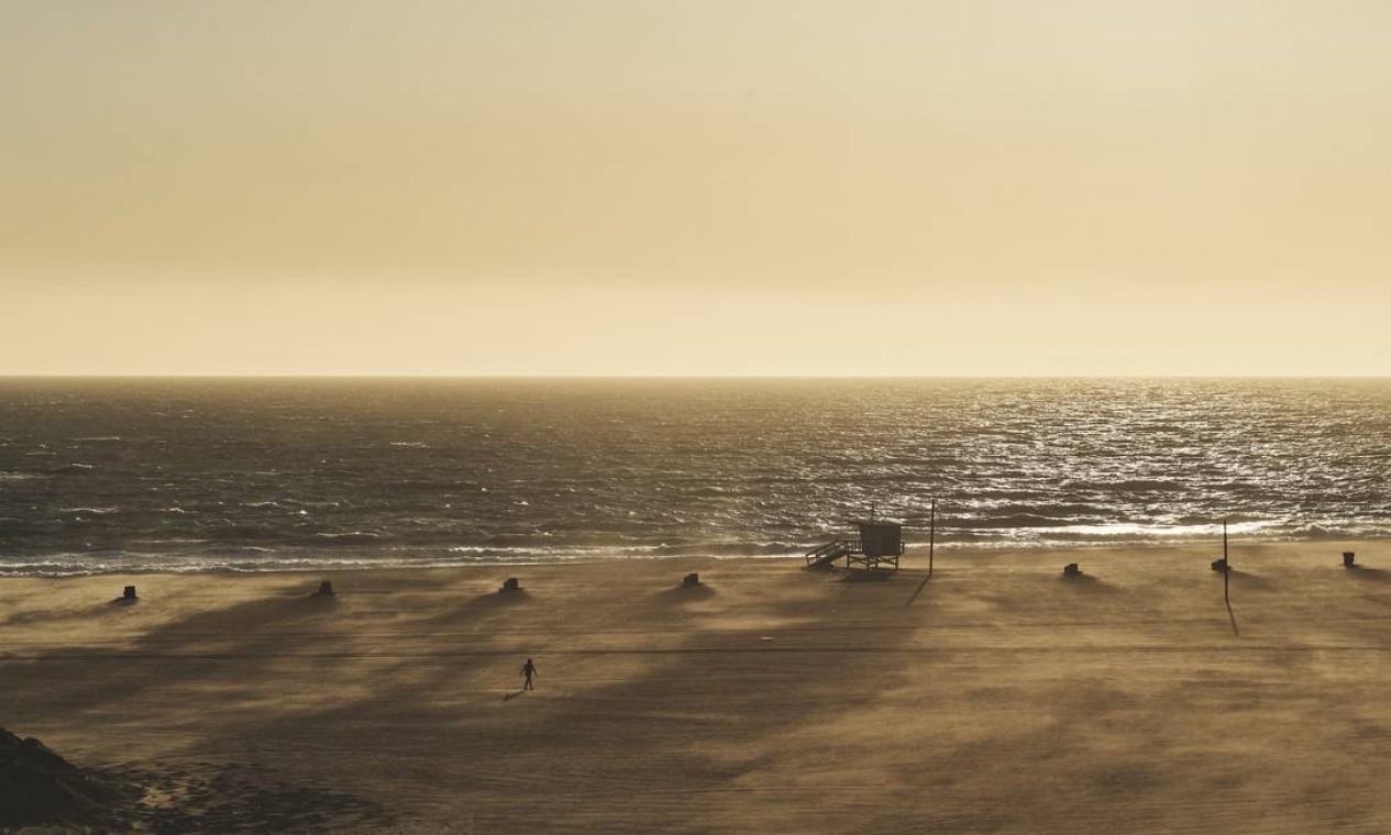 Um oceano imutável, uma praia quase irreconhecível em Santa Monica, Los Angeles Foto: Philip Cheung / NYT