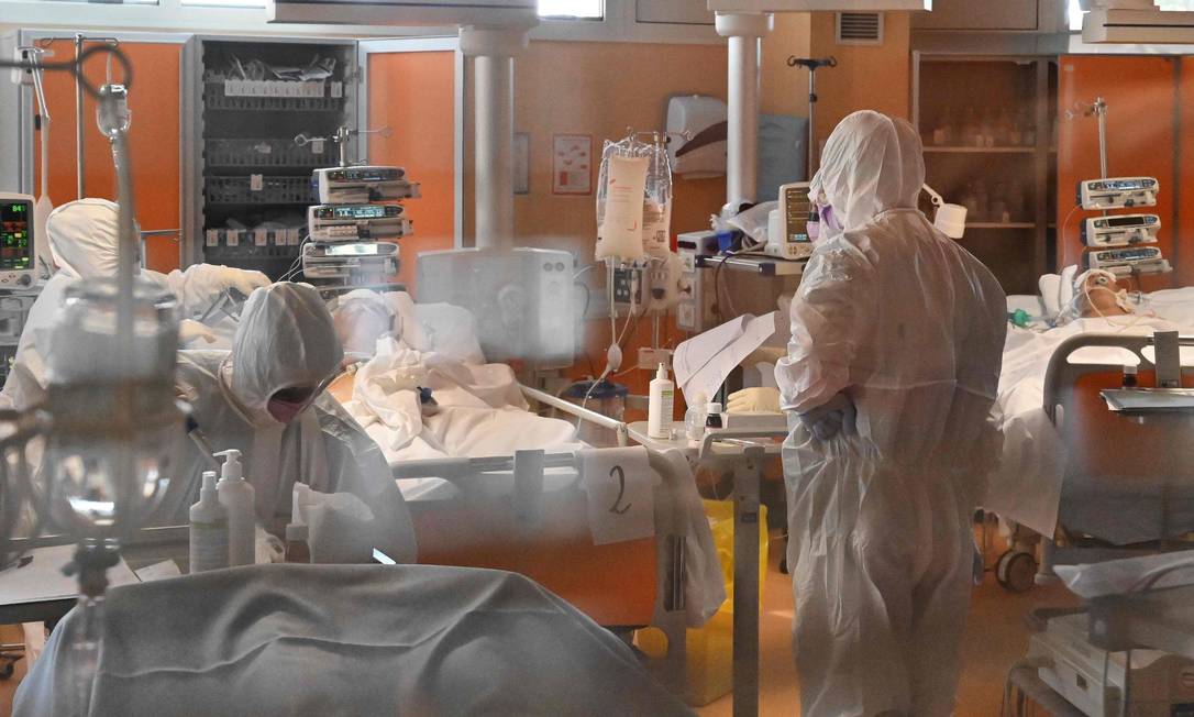 Médicos e enfermeiros vestem roupas de proteção em unidade de terapia intensiva de nível 3 voltada para pacientes de Covid-19 em hospital nos arredores de Roma, capital da Itália Foto: ALBERTO PIZZOLI / AFP