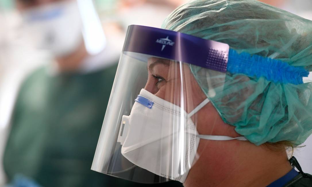 Enfermeira usa máscara e equipamento de proteção em hospital em Essen, na Alemanha Foto: INA FASSBENDER / AFP