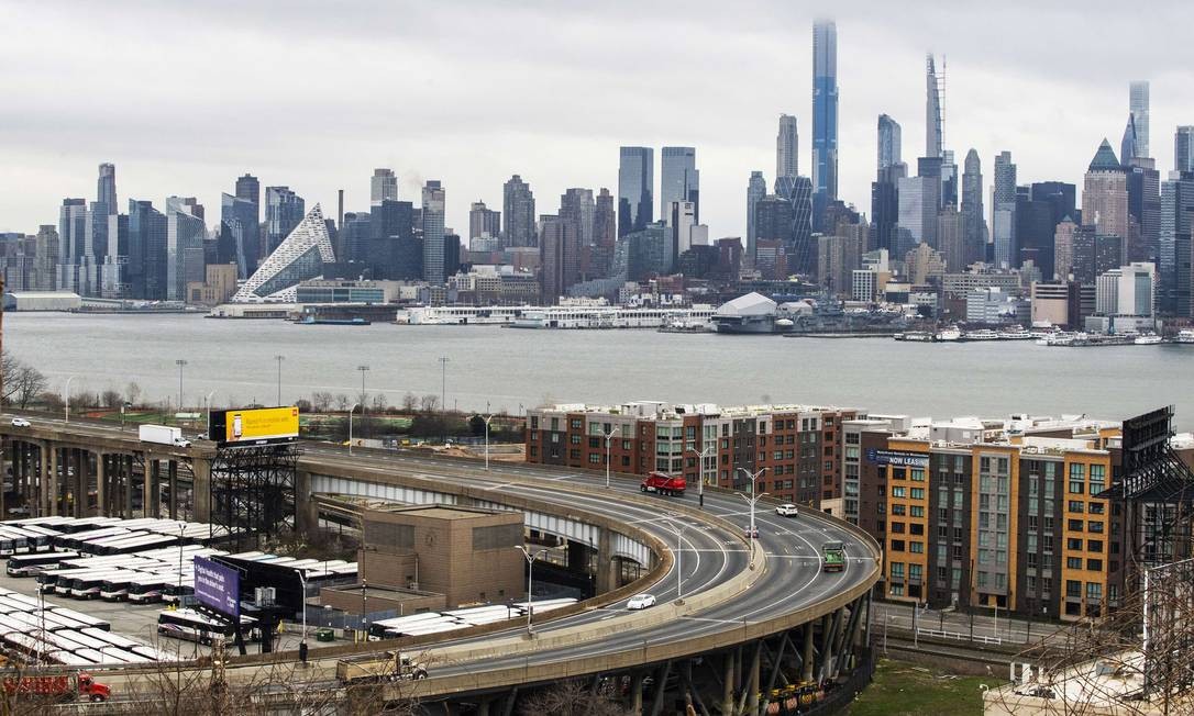 Via expressa que liga o estado de Nova Jersey à cidade de Nova York (ao fundo) aparece vazia em Weehawken (NJ) nesta quarta-feira; NY concentra o maior número de casos e está sob confinamento após ordem do governador, Andrew Cuomo Foto: EDUARDO MUNOZ ALVAREZ / AFP