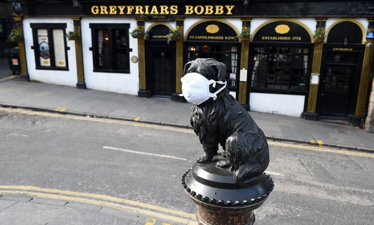 Estátua do cachorro Greyfriars Bobby, que ficou conhecido em Edimburgo, Escócia, no século XIX por ter passado 14 anos guardando o túmulo de seu dono, também recebeu uma máscara facial Foto: ANDY BUCHANAN / AFP