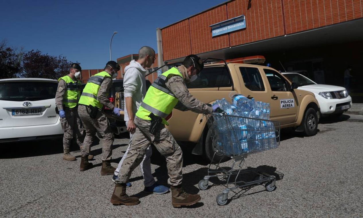 Membros do exército espanhol levam garrafas de água ao Hospital Severo Ochoa Foto: SUSANA VERA / REUTERS