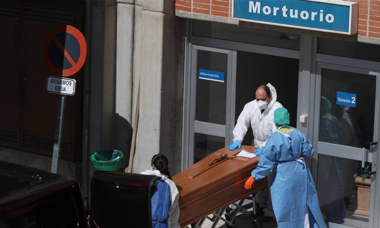 Trabalhadores funerários com roupas de proteção carregam um caixão para fora do necrotério no Hospital Severo Ochoa, durante o surto do novo coronavírus, em Leganes, Espanha Foto: SUSANA VERA / REUTERS