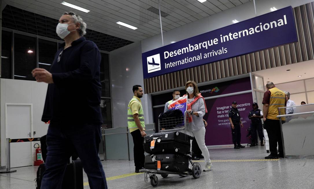 Passageiros desembarcam no Aeroporto Internacional do Galeão, no Rio, usando máscaras. Temor do coronavírus provocou queda brusca nas viagens de avião Foto: Ricardo Moraes / Reuters