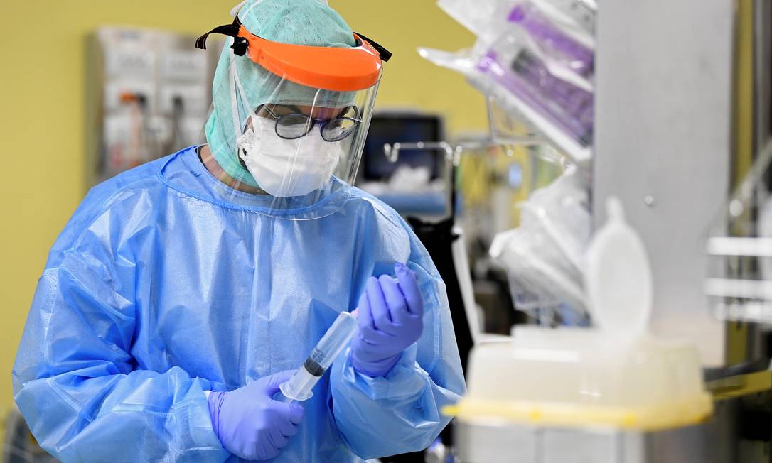 Médico com traje de proteção trata um paciente com coronavírus em uma unidade de terapia intensiva no hospital San Raffaele em Milão Foto: FLAVIO LO SCALZO / REUTERS
