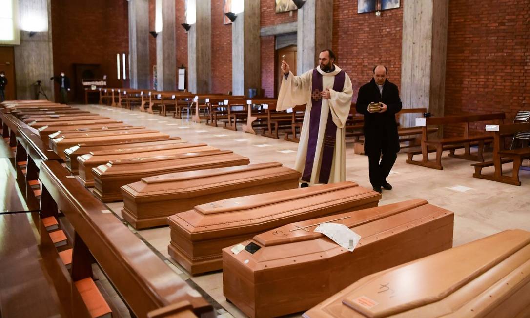 Padre abençoa caixões de mortos por Covid-19 na Itália Foto: PIERO CRUCIATTI / AFP
