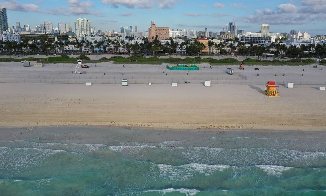 Praia deserta em Miami Beach, Flórida. As autoridades da cidade de Miami Beach fecharam a área da praia que é popular entre os estudantes de faculdade e pediram que se abstivessem de grandes reuniões Foto: JOE RAEDLE / AFP