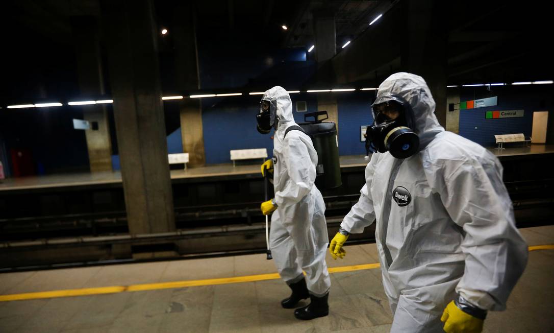 Membros das forças armadas usam roupas de proteção contra a Covid-19 para desinfectar uma estação de metrô em Brasília Foto: ADRIANO MACHADO / REUTERS