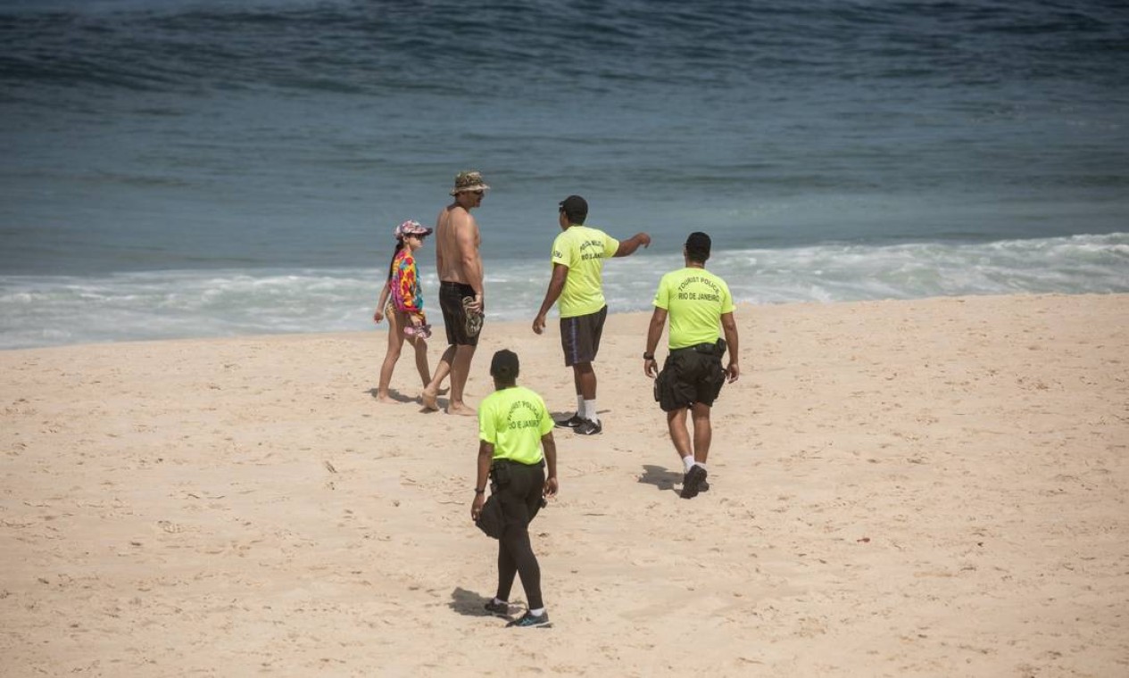Em Ipanema, policiais advertiramquem descumpria decreto do governo de estado que proíbe atividades nas praias do Rio Foto: BRENNO CARVALHO / Agência O Globo
