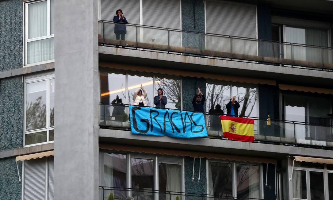 Isolados em suas casas, espanhóis aplaudem da varanda os profissionais da saúde do hospital Fundação Jimenez Diaz, em Madri Foto: SERGIO PEREZ / REUTERS