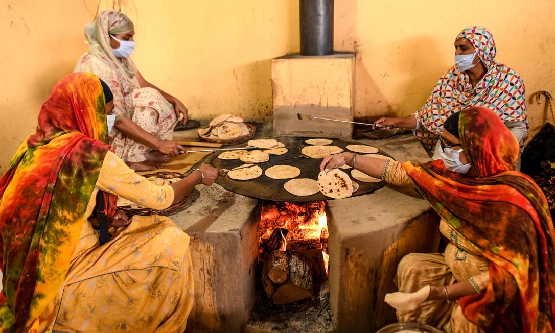Voluntárias cozinham para população mais pobre durante quarentena na Índia Foto: NARINDER NANU / AFP