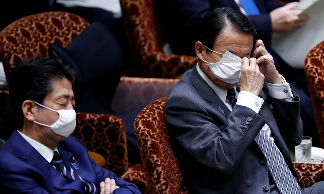 Taro Aso, ministro da Economia do Japão, e o premier Shinzo Abe (à esquerda) participam de reunião no Parlamento para discutir o avanço do coronavírus Foto: ISSEI KATO / REUTERS/01-04-2020