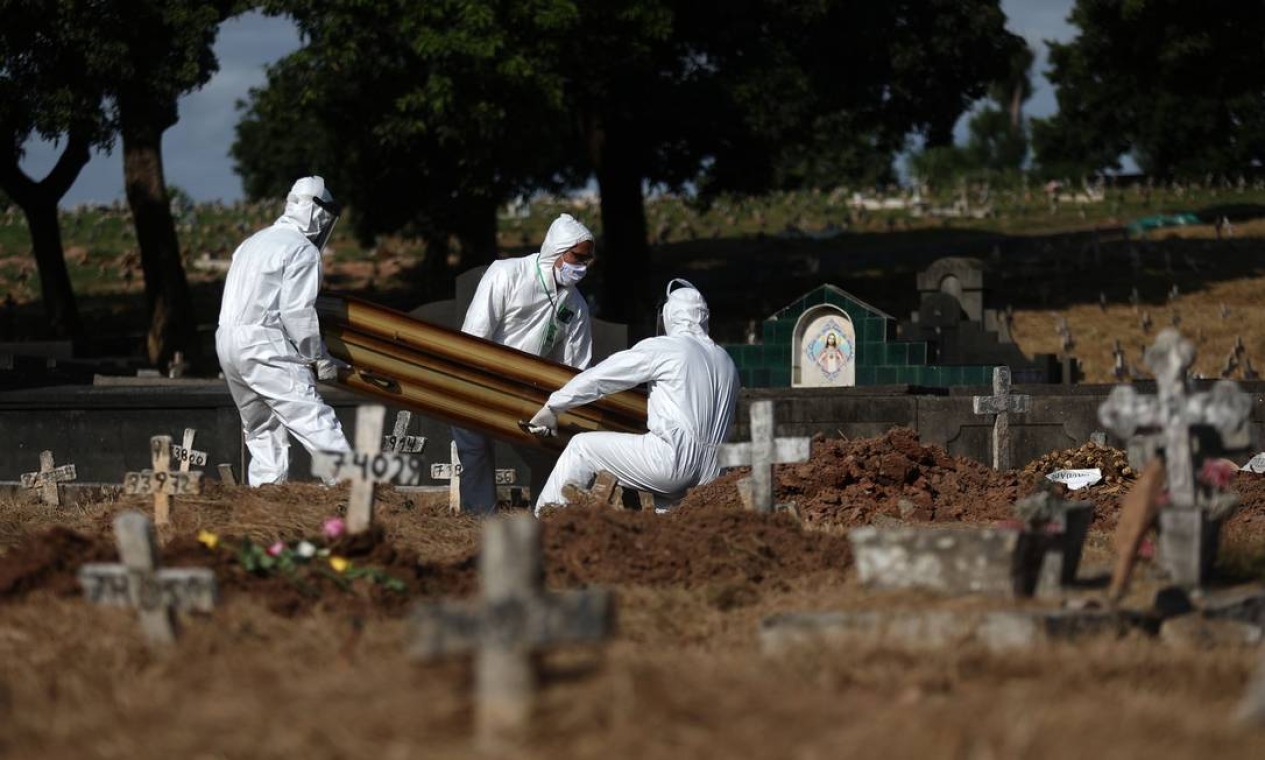 Por causa da pandemia de Covid-19, medidas de segurança estão sendo adotadas não só pelos funcionários dos cemitérios, como também por familiares e demais enlutados, que passaram a usar máscaras durante os funerais Foto: FABIO MOTTA / Agência O Globo