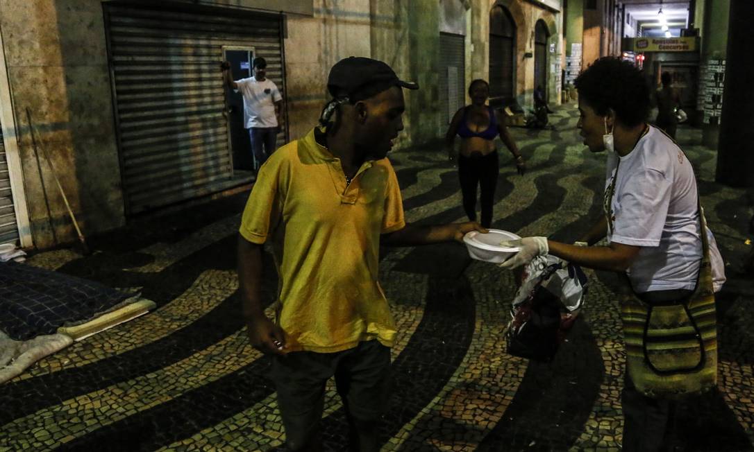 Voluntários distribuem alimentos e artigos de higiene pessoal para pessoas em situação de rua no centro do Rio Foto: Guito Moreto / Agência O Globo - 01/04/2020