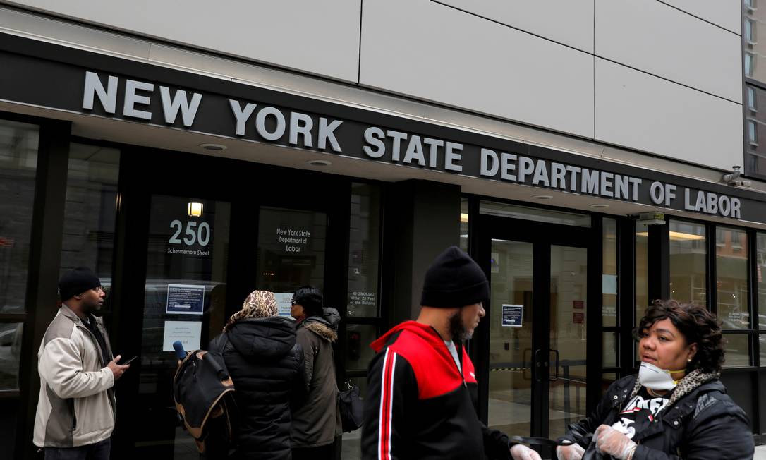 Pessoas se reúnem na entrada dos escritórios do Departamento de Trabalho do Estado de Nova York, que foram fechados ao público devido ao surto da covid-19 no bairro do Brooklyn Foto: Andrew Kelly / REUTERS