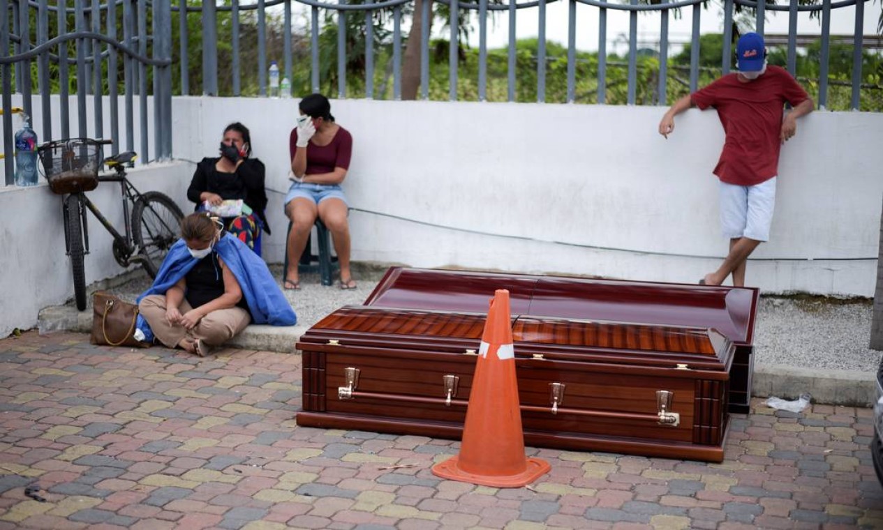 Pessoas esperam ao lado de caixões do lado de fora do Hospital Geral Guasmo Sur, depois que o Equador relatou novos casos da Covid-19, provocada pelo novo coronavírus, em Guayaquil, no Equador Foto: STRINGER / REUTERS