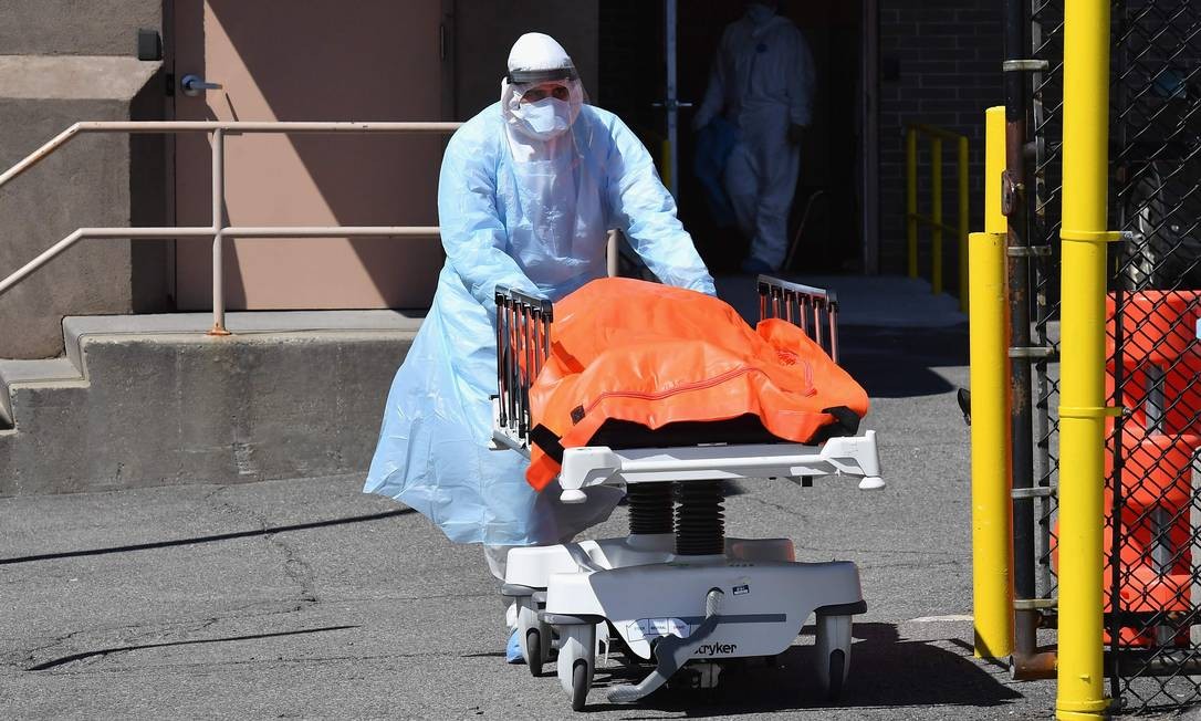 Equipe médica transfere corpos do Wyckoff Heights Medical Center para um caminhão refrigerado, no Brooklyn, em Nova York. Os EUA registraram o maior número diário de mortes ligadas à Covid-19 desde o início da pandemia da doença, no ano passado Foto: ANGELA WEISS / AFP