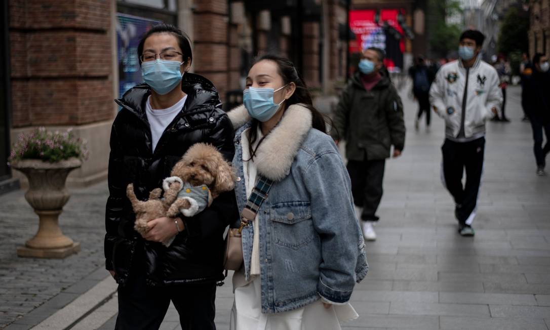 Pessoas andando pelas ruas de Wuhan, na China Foto: NOEL CELIS / AFP