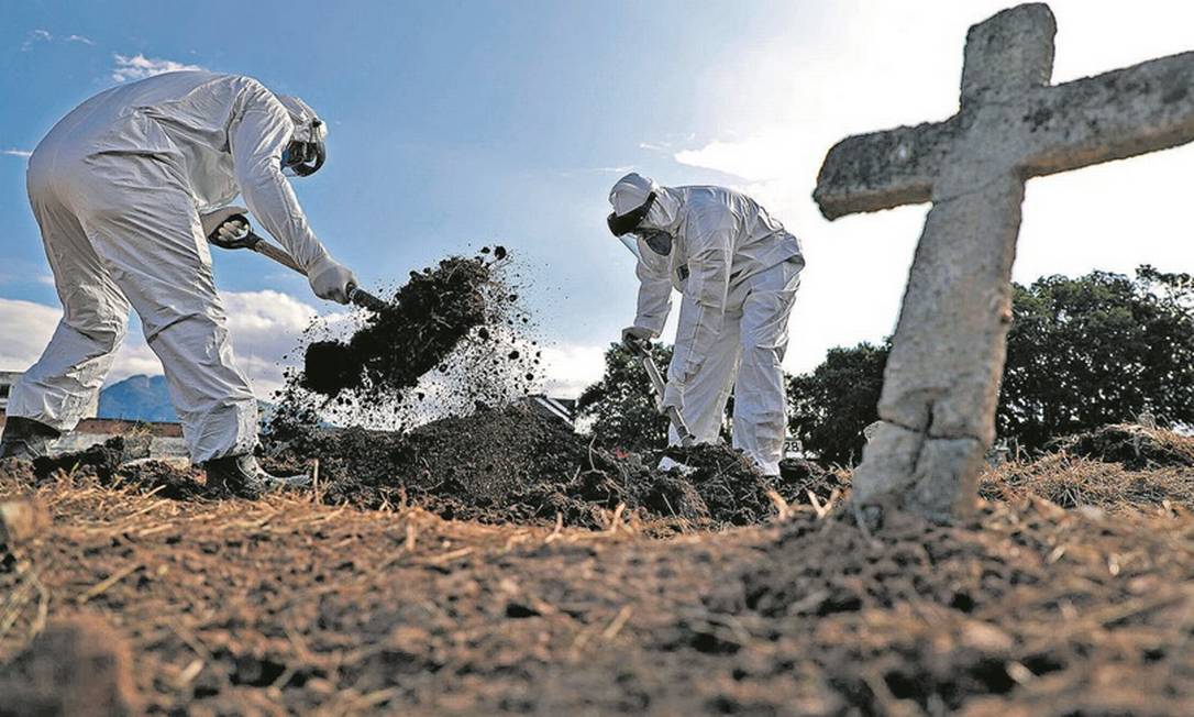 Coveiros do Cemitério do Caju usam equipamentos de proteção para enterrar um idoso que morreu de Covid-19 Foto: Fabio Motta / Agência O Globo