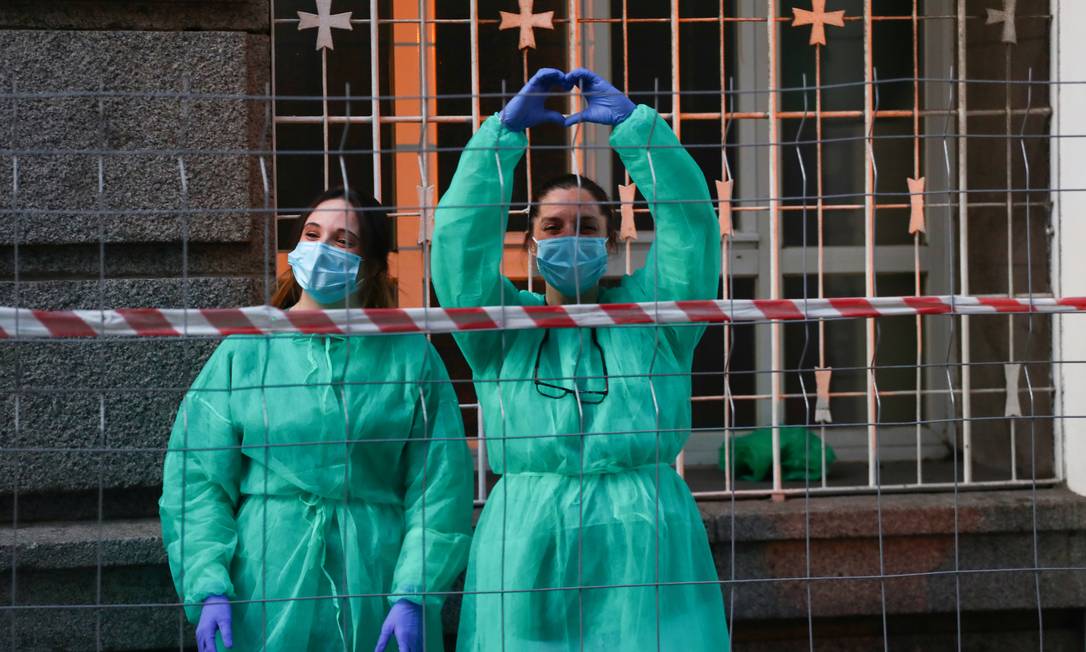 Médicas do hospital La Princesa agradecem a aplausos de moradores em Madri: desaceleração dos casos de coronavírus Foto: SERGIO PEREZ / REUTERS