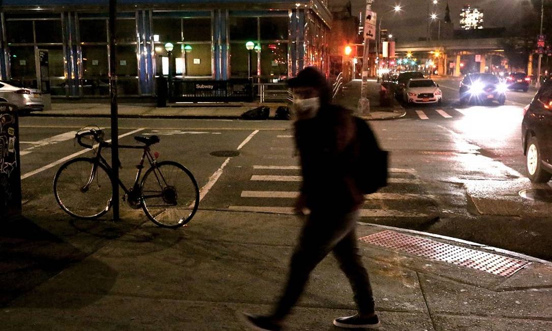 Homem com máscara caminha pelas ruas de Nova York, nos EUA. Foto: Yana Paskova / AFP