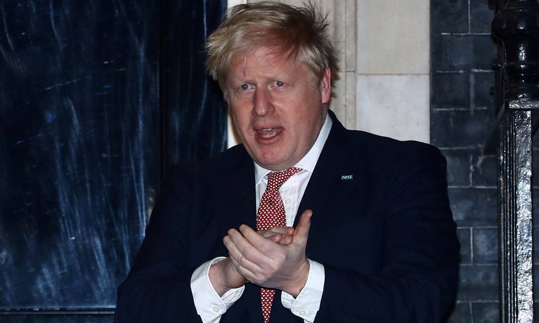 O primeiro-ministro britânico, Boris Johnson, aplaude médicos um dia antes de ser diagnosticado com coronavírus, em 26 de março Foto: Hannah Mckay / London