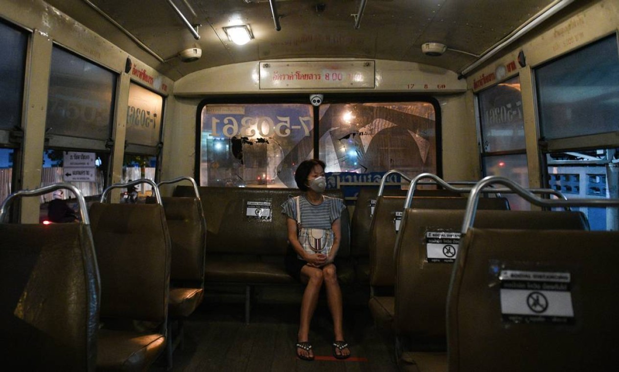 Mulher com máscara protetora senta-se em um assento social de um ônibus em Bangkok, Tailândia Foto: CHALINEE THIRASUPA / REUTERS