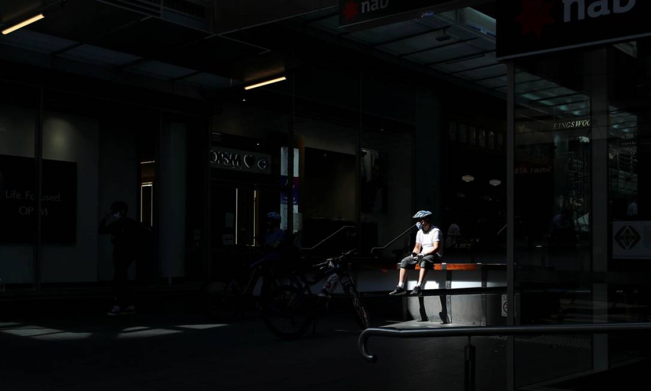 Um entregador, de bicicleta, usa uma máscara facial durante a implementação de regras mais rígidas de distanciamento social e autoisolamento para limitar a propagação da doença por coronavírus em Sydney, Austrália Foto: LOREN ELLIOTT / REUTERS