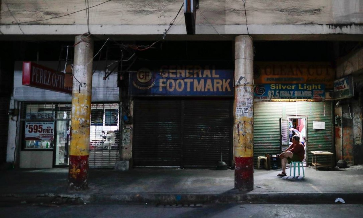 Um homem fica do lado de fora de lojas fechadas após o bloqueio na capital das Filipinas para impedir a propagação da Covid-19, em Manila, capital do país Foto: ELOISA LOPEZ / REUTERS