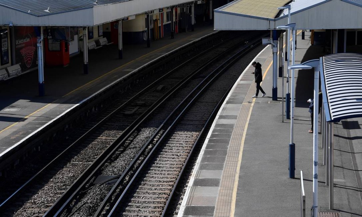 Um passageiro aguarda um trem em uma plataforma vazia na estação de Richmond, oeste de Londres Foto: TOBY MELVILLE / REUTERS