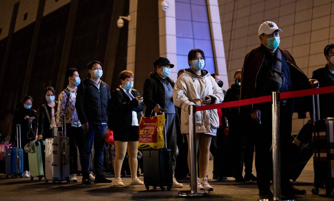Chineses com máscaras em estação em Wuhan, no primeiro dia após fim do isolamento total Foto: NOEL CELIS / AFP