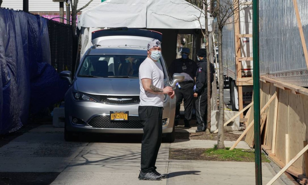 Um carro funerário remove um corpo de um caminhão de refrigerado fora do Hospital Wyckoff, no Brooklyn Foto: BRYAN R. SMITH / AFP