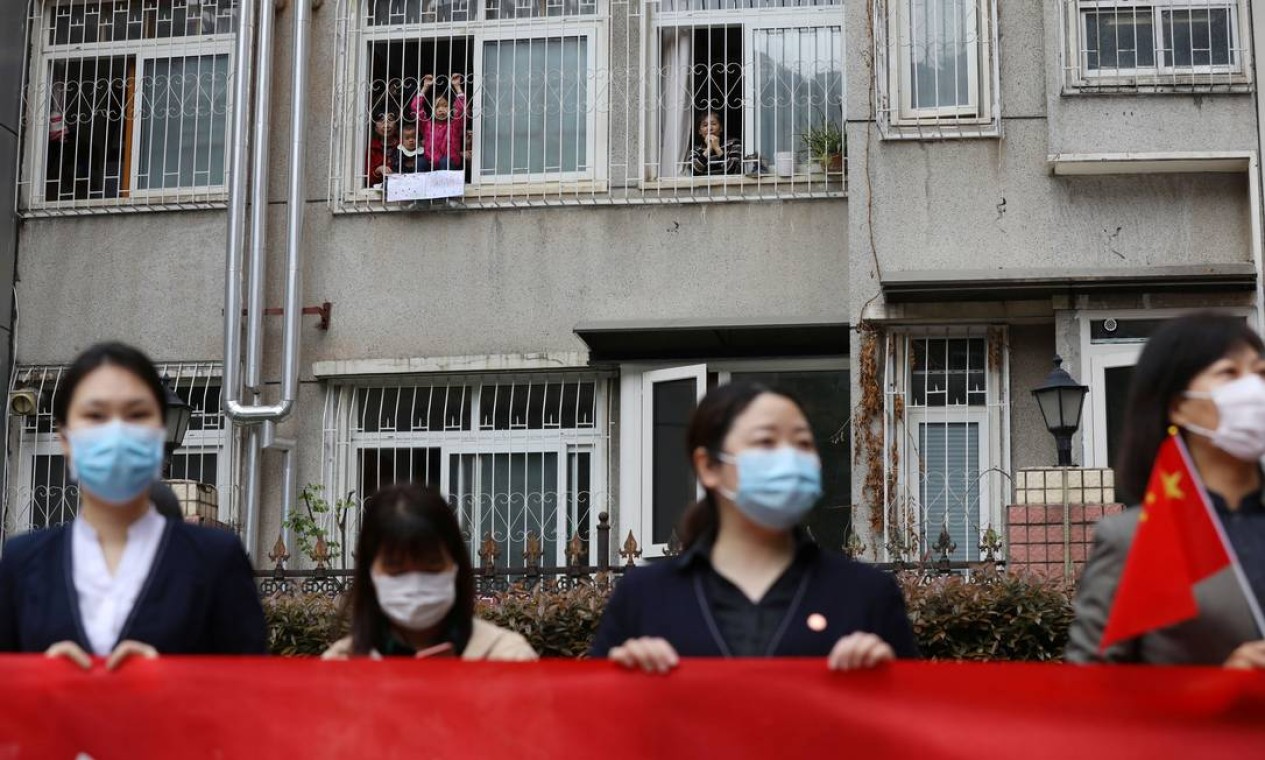 Moradores de um condomínio se despedem da equipe médica da província de Guizhou que está deixando Wuhan, no fim de março Foto: CHINA DAILY / REUTERS