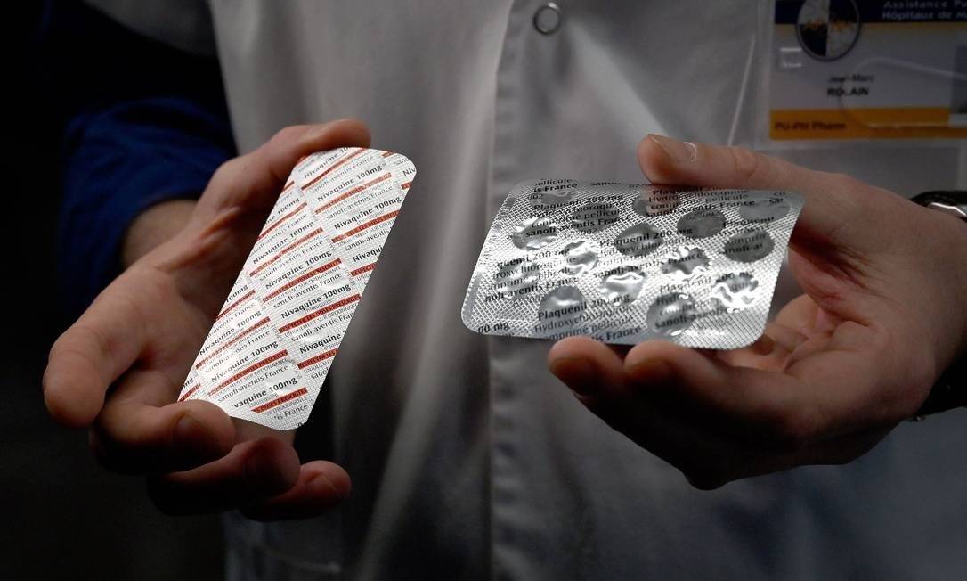 Médicos exibem embalagens de cloroquina e de hidroxicloroquina Foto: GERARD JULIEN / AFP