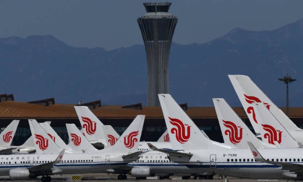 Aviões da Air China estacionados no pátio do aeroporto de Pequim Foto: Greg Baker / AFP