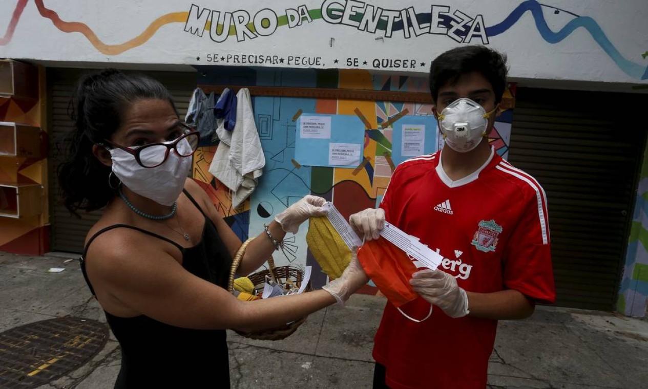 Vinicius, aluno do 3° ano do Ensino Médio, e sua mãe, Natália Ourique, mostram máscaras que estão colocando à disposição de quem precisa Foto: FABIANO ROCHA / Agência O Globo