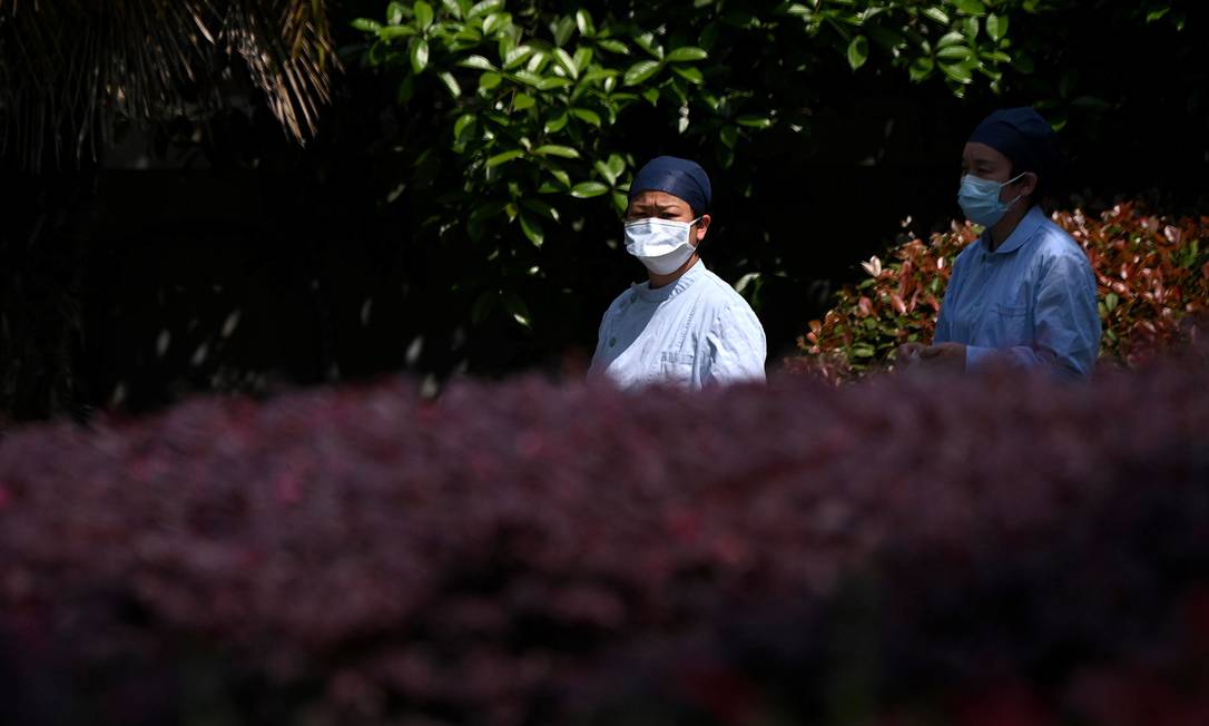 Enfermeiras usando máscaras caminham do lado de fora do hospital Wuhan Jinyintan na província de Hubei Foto: NOEL CELIS / AFP/09-04-2020