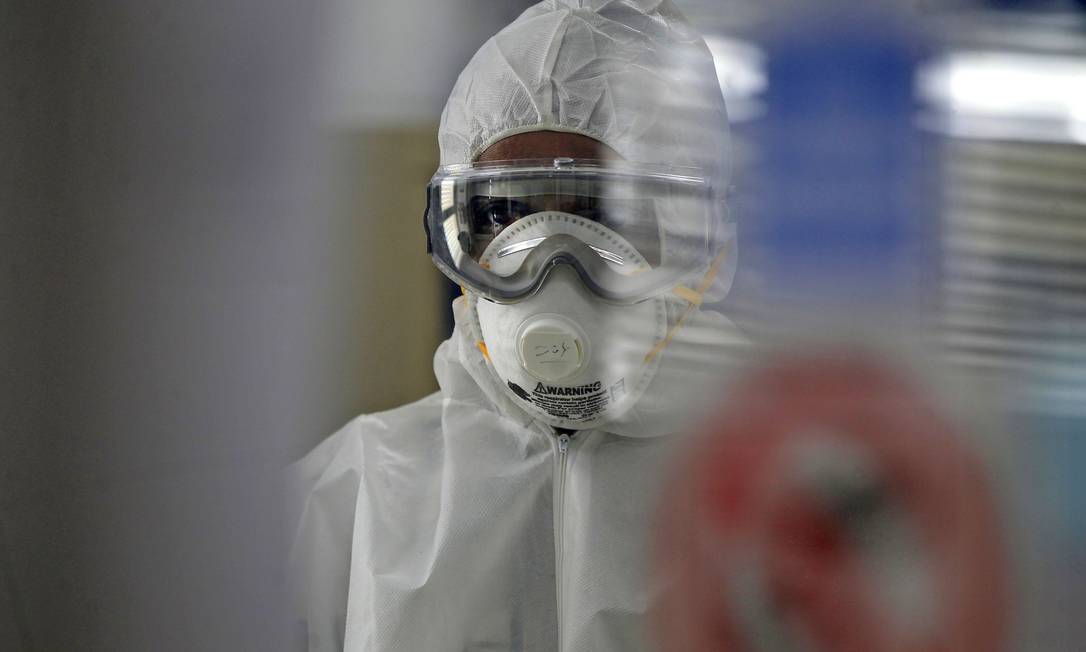 Técnico testa componentes em busca de um controle para pandemia do coronavírus Foto: MOHAMMED HUWAIS/AFP